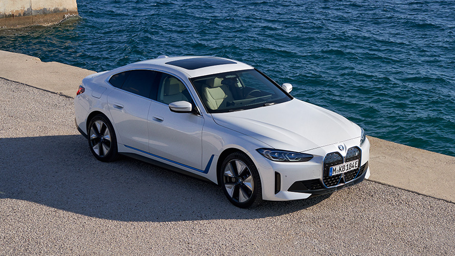 Vista anteriore a tre quarti della BMW i4 eDrive40 G26 2021 sul molo BMW i4 eDrive40 G26 2021 Mineral White vista anteriore a tre quarti sul molo