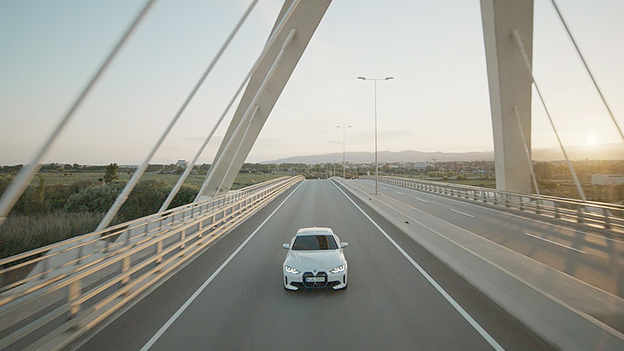 Vista anteriore a tre quarti della BMW i4 eDrive40 G26 2021 in movimento BMW i4 eDrive40 G26 2021 Mineral White vista anteriore a tre quarti in movimento