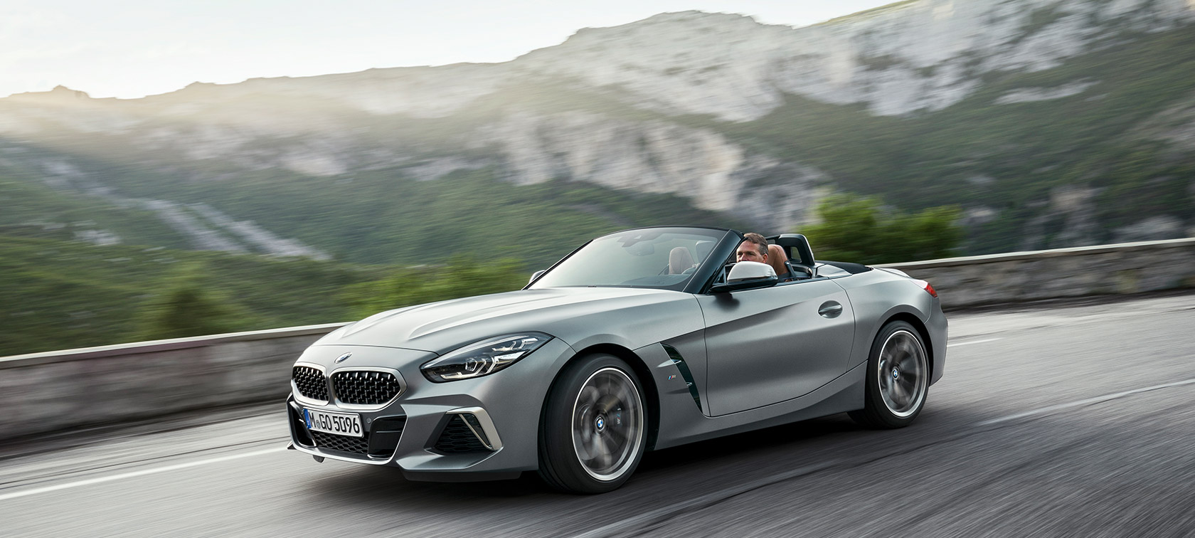 BMW Z4 M40i G29 in movimento davanti a sfondo collinare BMW Z4 Roadster M40i G29 2019 Cabrio BMW Individual Frozen Grey metallizzato grigio vista anteriore a tre quarti davanti a sfondo collinare