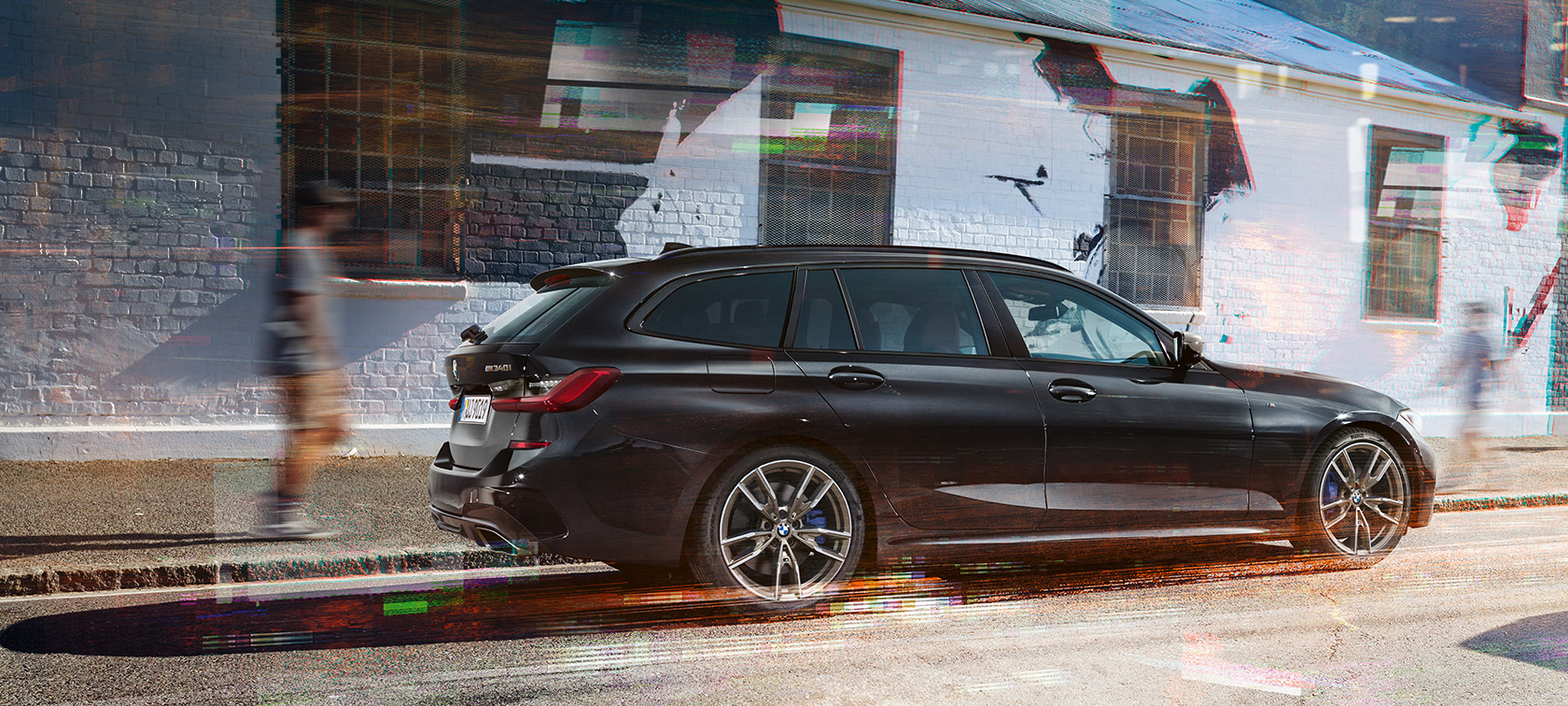 Vista laterale della BMW M340i xDrive Touring (G21) BMW M340i xDrive Touring (G21) Black Sapphire metallizzato - Vista laterale su strada