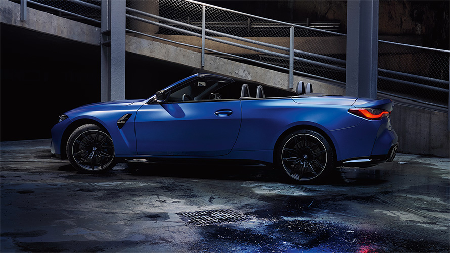 BMW M4 Competition Cabrio con M xDrive G83 2021 vista laterale con capote aperta BMW M4 Competition Cabrio con M xDrive G83 2021 Frozen Portimao Blue metallizzato vista laterale con capote aperta