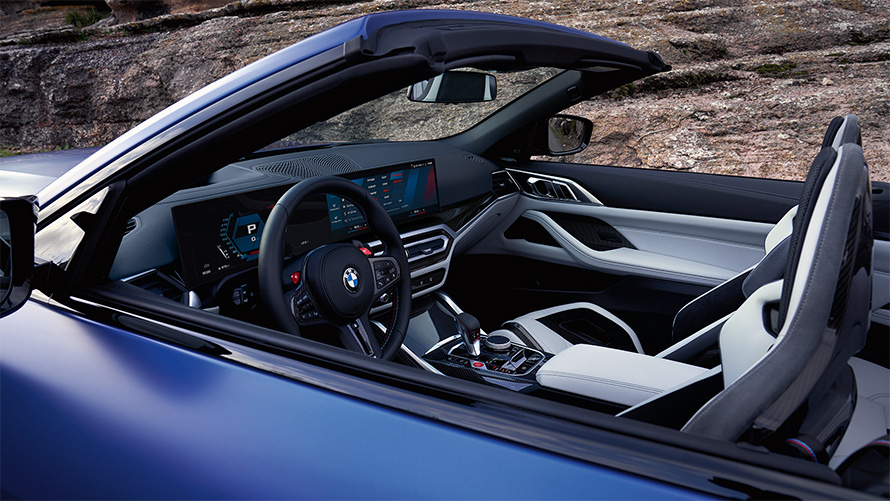 BMW M4 Competition Cabrio con M xDrive G83 2021 abitacolo con capote aperta BMW M4 Competition Cabrio con M xDrive G83 2021 BMW Individual Frozen Portimao Blue metallizzato cockpit e interni con capote aperta