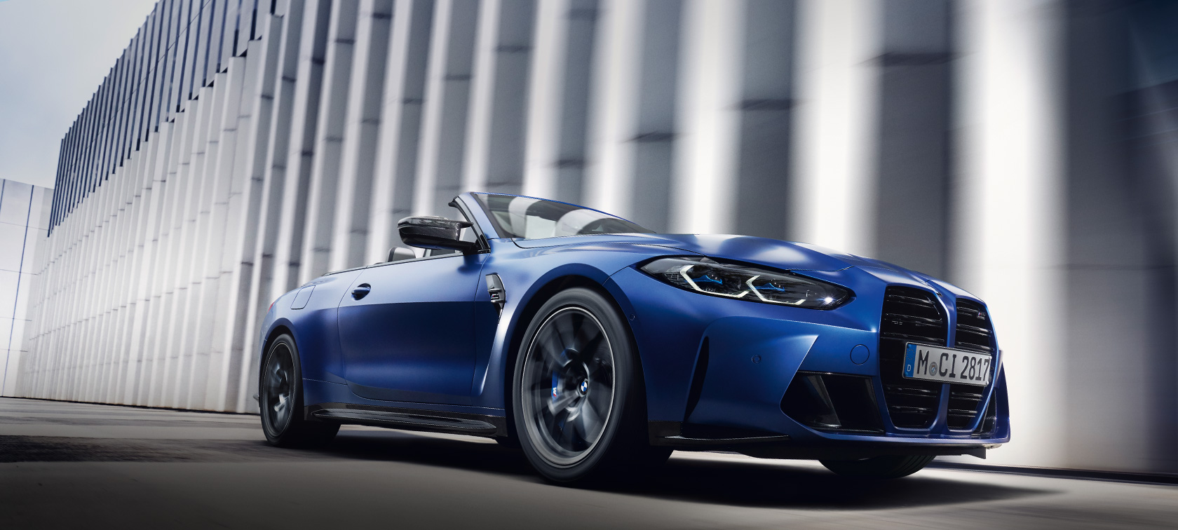BMW M4 Competition Cabrio con M xDrive G83 2021 BMW Individual Frozen Portimao Blue metallizzato vista laterale da ferma con prospettiva dal basso