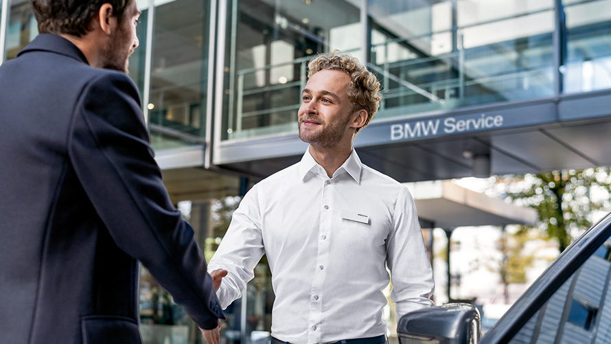 Un collaboratore di un Centro BMW Service dà il benvenuto a un cliente Un collaboratore di un Centro BMW Service dà il benvenuto a un cliente