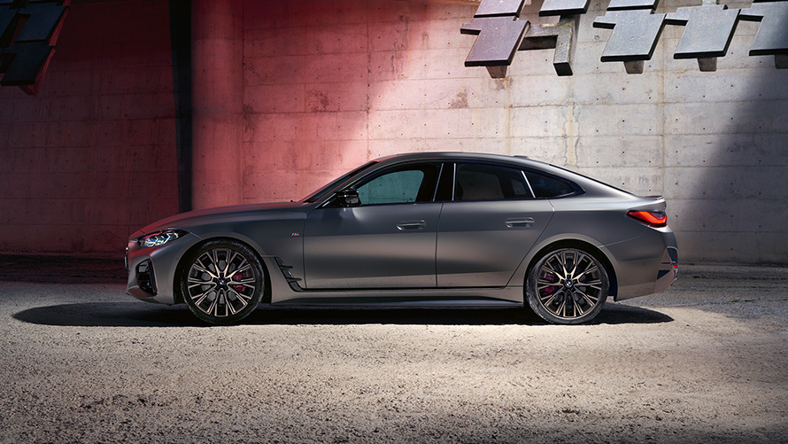 BMW M440i xDrive Gran Coupé G26 2021 Vista laterale BMW M440i xDrive Gran Coupé G26 2021 Frozen Pure Grey metallizzato Vista laterale davanti a una parete