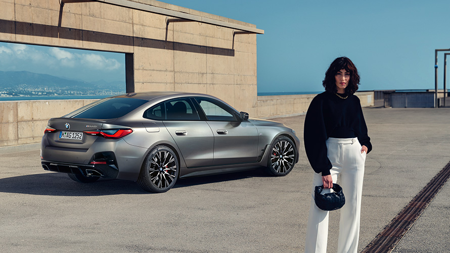 BMW M440i xDrive Gran Coupé G26 2021 Vista posteriore a tre quarti con modella BMW M440i xDrive Gran Coupé G26 2021 Vista posteriore a tre quarti con modella