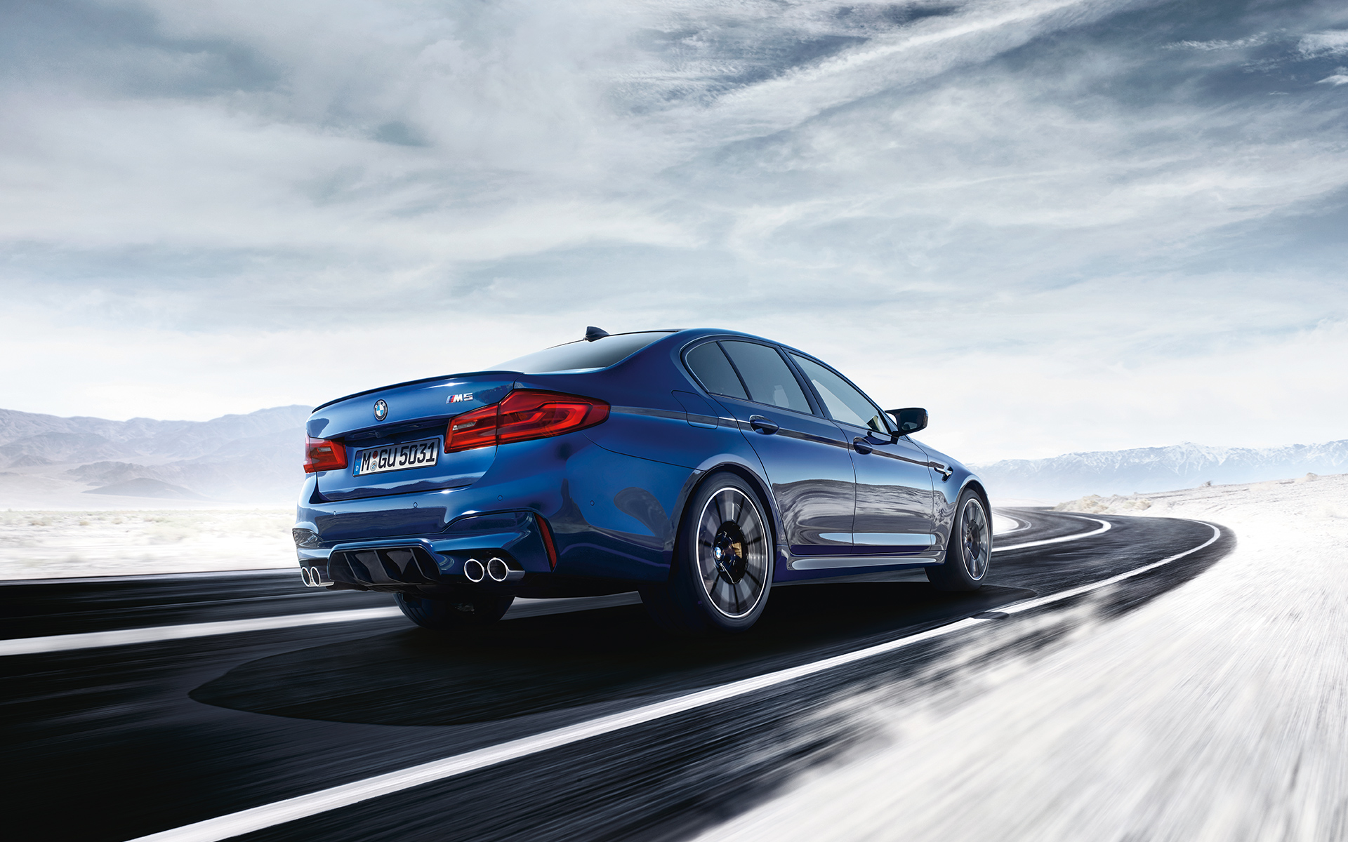 BMW M5 Sedan blu sfreccia velocemente sull'asfalto BMW M5 Sedan blu sfreccia velocemente sull'asfalto