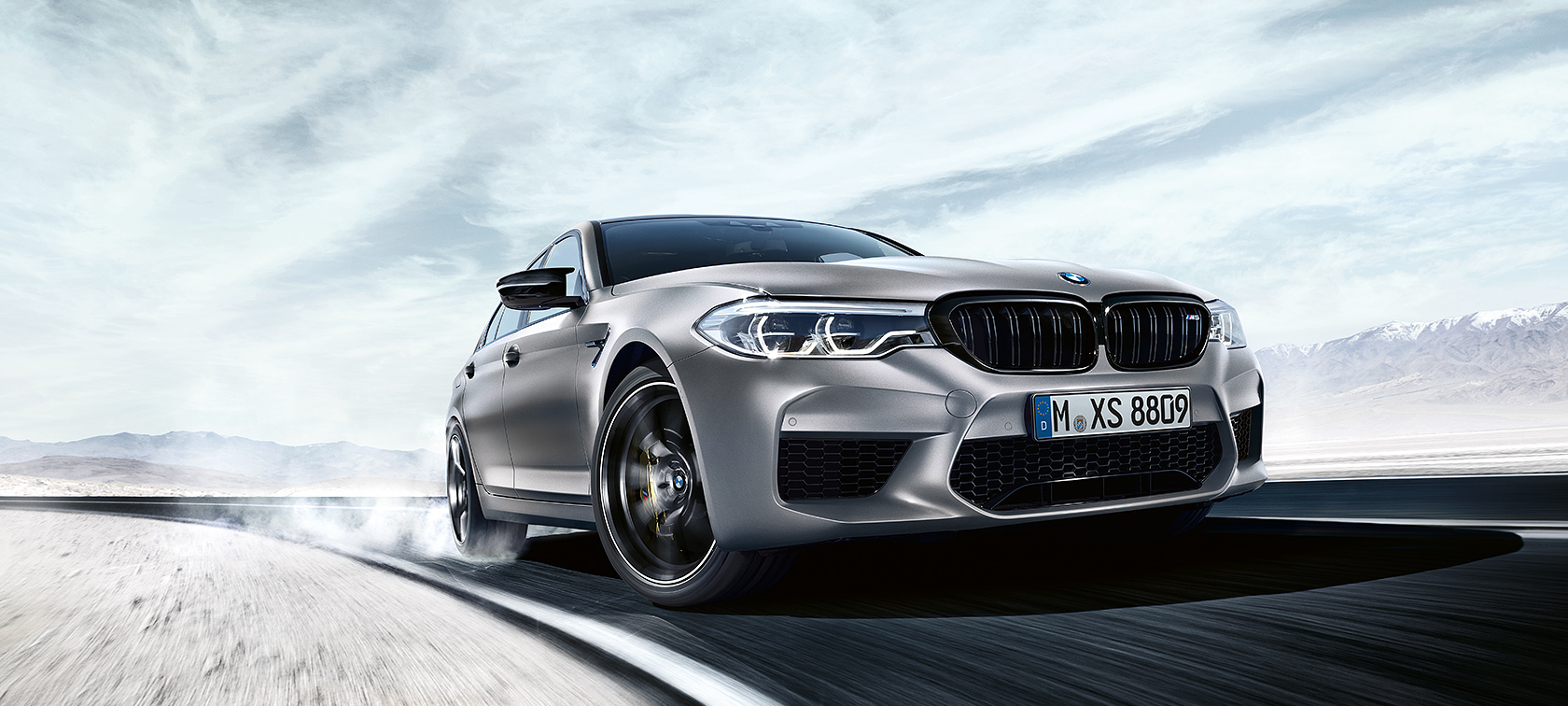 BMW M5 Competition in azione BMW M5 Competition grigia in azione nel deserto