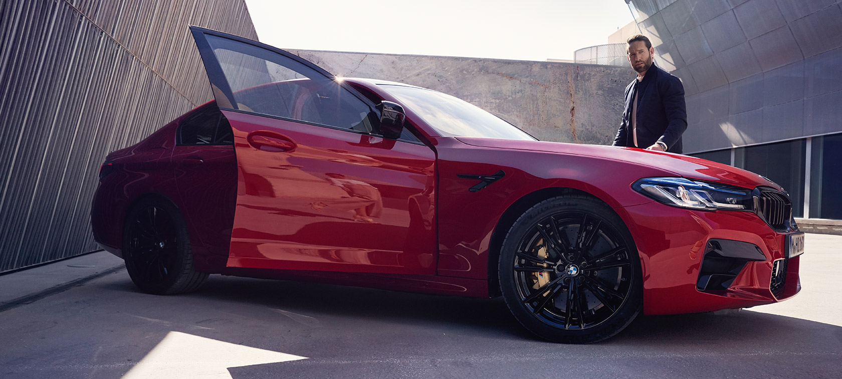 BMW M5 Competition F90 LCI Facelift 2020 vista laterale con portiera aperta BMW M5 Competition F90 LCI Facelift 2020 BMW Individual Imola Red vista laterale con portiera aperta
