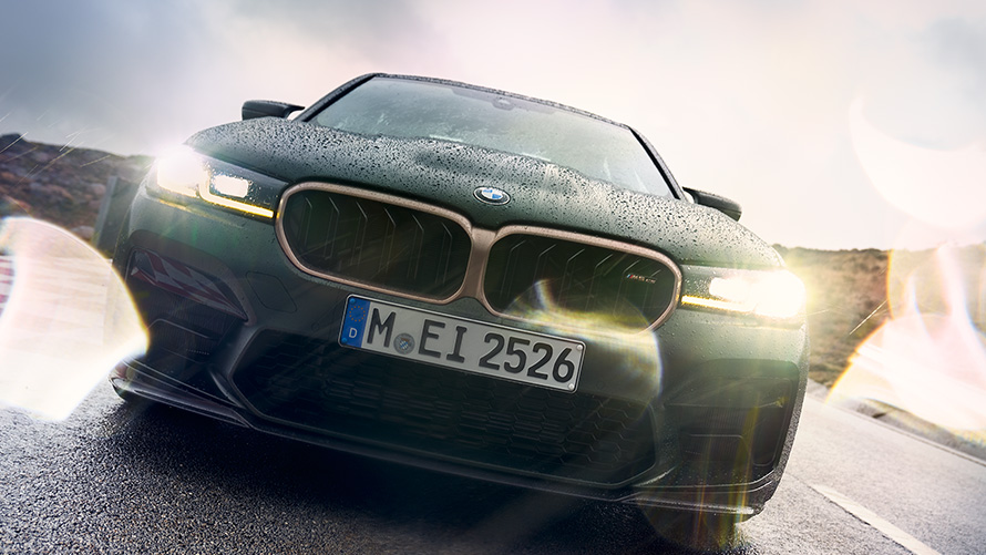 BMW M5 CS F90 2021 Frozen Deep Green metallizzato, vista anteriore con gruppi ottici attivati