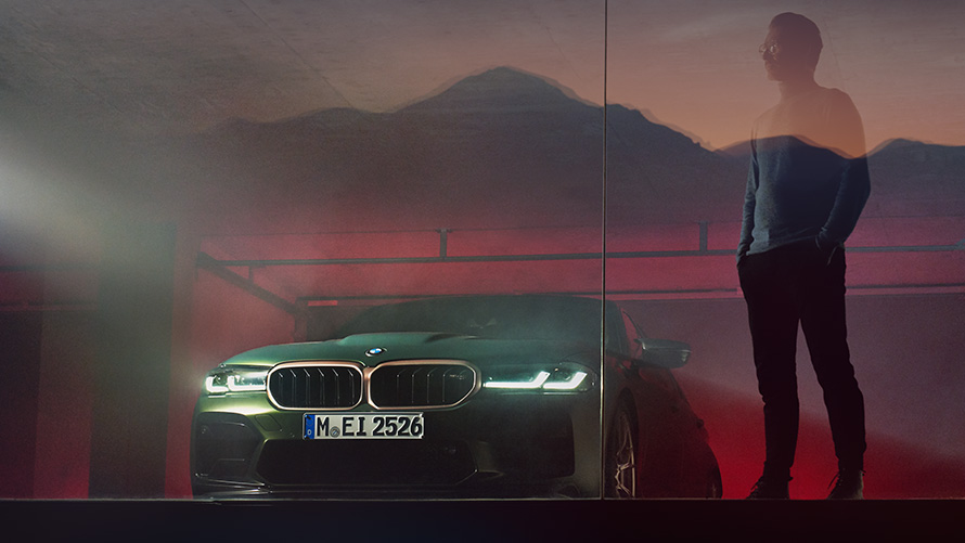 BMW M5 CS F90 2021 Vista anteriore con un uomo BMW M5 CS F90 2021 Frozen Deep Green metallizzato Vista anteriore con un uomo