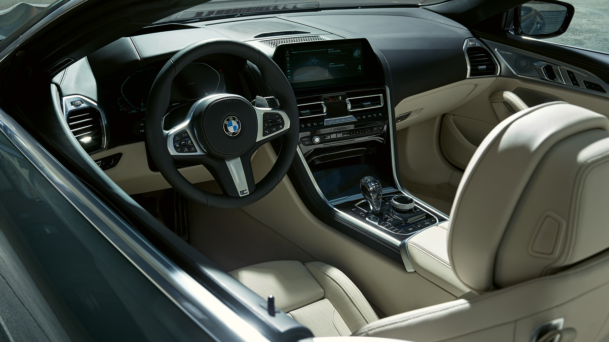 BMW M850i xDrive Cabrio, cockpit G14. BMW M850i xDrive Cabrio in Dravit Grey metallizzato con capote aperta, cockpit con volante in pelle M G14.