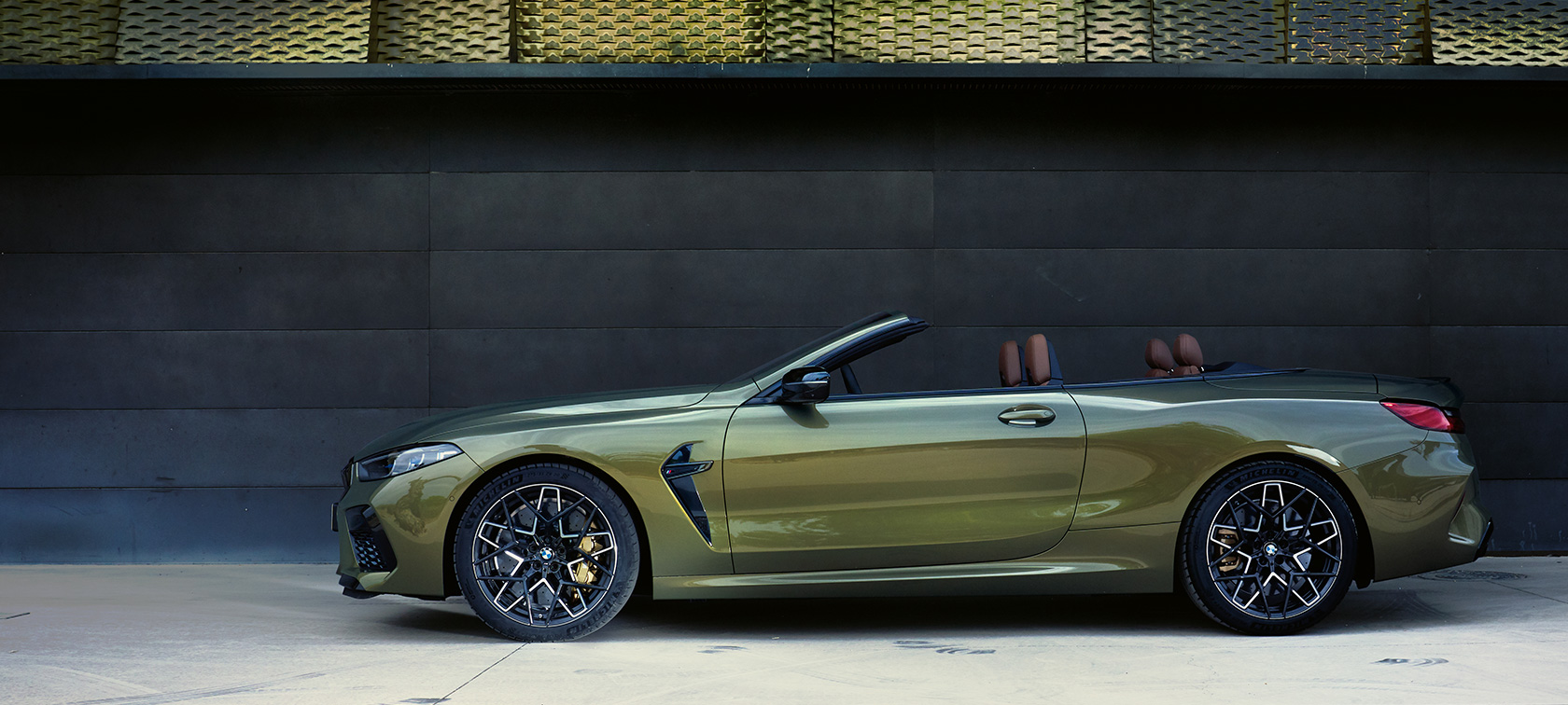 BMW M8 Competition Cabrio F91 LCI Facelift 2022 Vista laterale da ferma BMW M8 Competition Cabrio F91 LCI Facelift 2022 BMW Individual Brass metallizzato Vista laterale da ferma con portiera aperta e modella