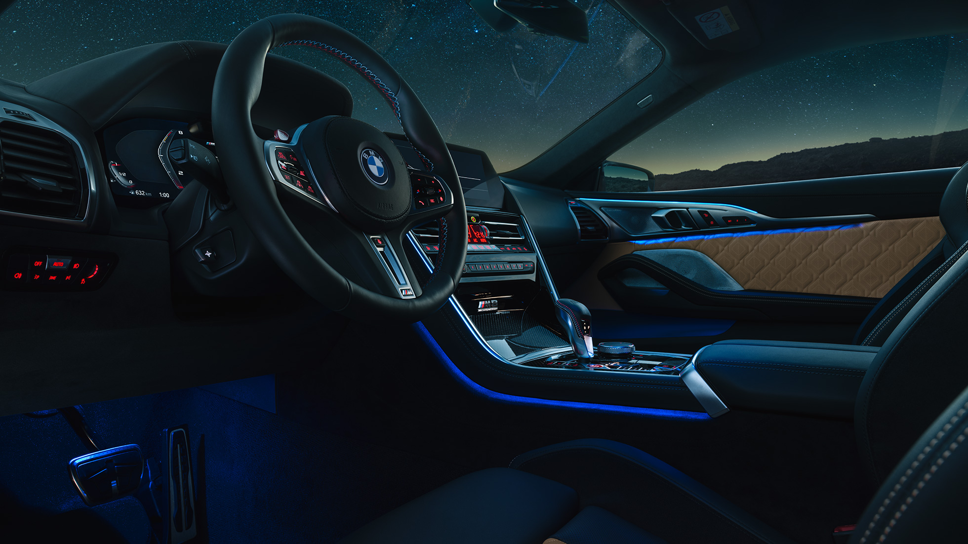 BMW M8 Competition Coupé, cockpit F92. BMW M8 Competition Coupé, cockpit di notte con volante in pelle M e luce ambiente blu F92.