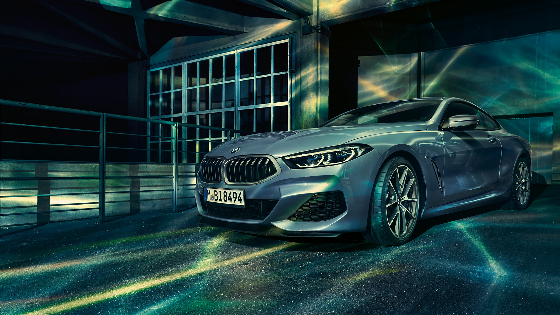 BMW M850i xDrive Coupé, vista frontale di tre quarti G15. BMW M850i xDrive Coupé in Barcelona Blue metallizzato, vista frontale di tre quarti in sosta davanti a un edificio G15.