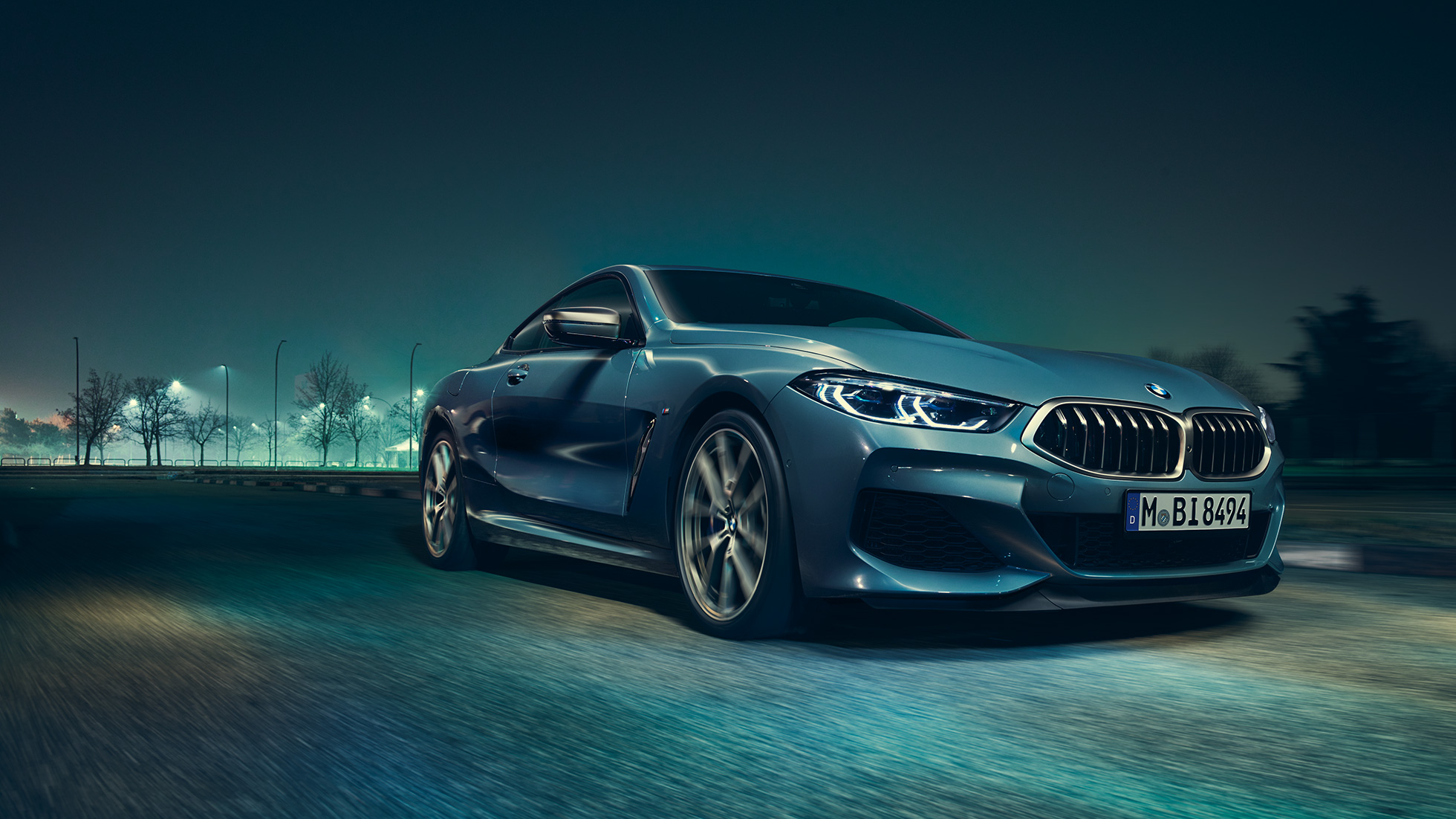 BMW M850i xDrive Coupé, vista frontale di tre quarti da sinistra G15. BMW M850i xDrive Coupé in Barcelona Blue metallizzato, vista frontale di tre quarti da sinistra, in marcia di notte G15.