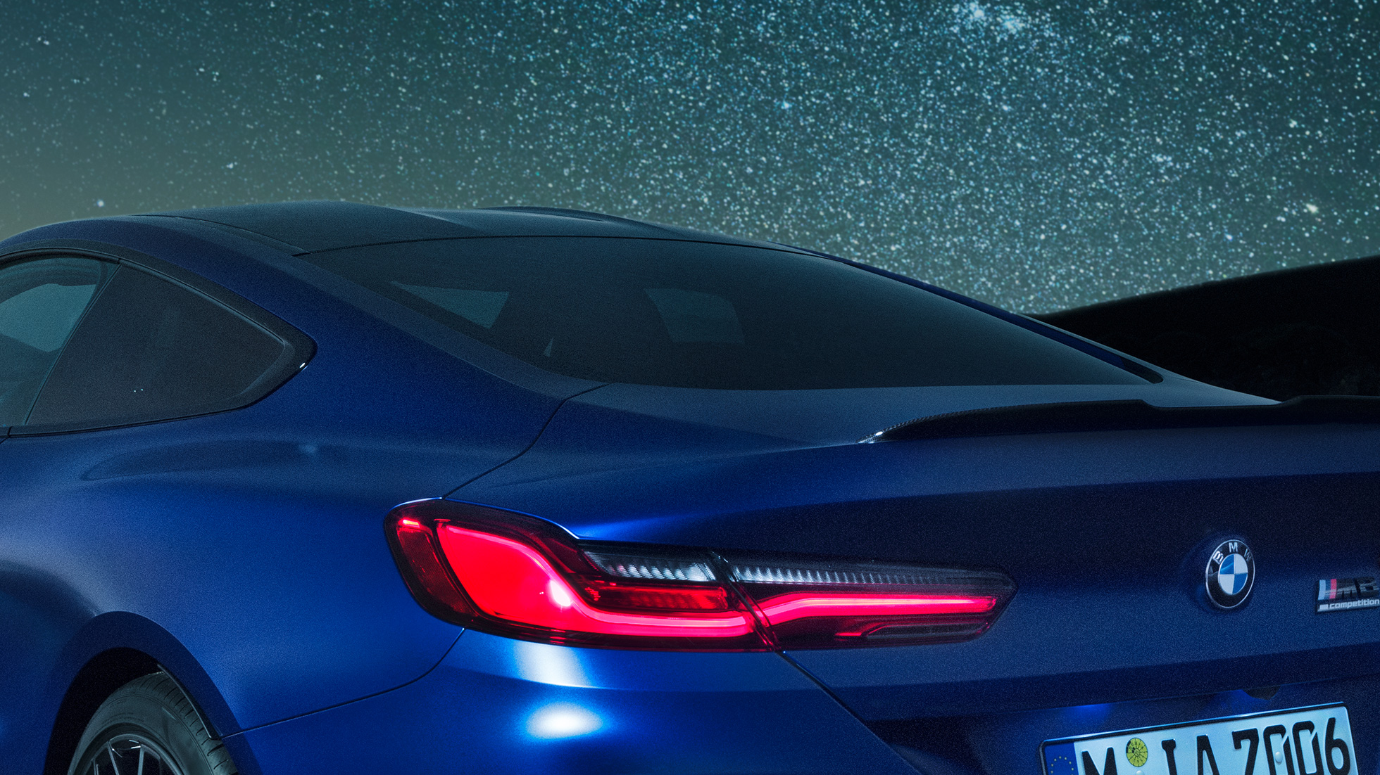 Spoiler posteriore M F92. BMW M8 Competition Coupé in Marina Bay Blue metallizzato, primo piano notturno delle spalle con spoiler posteriore in carbonio F92.