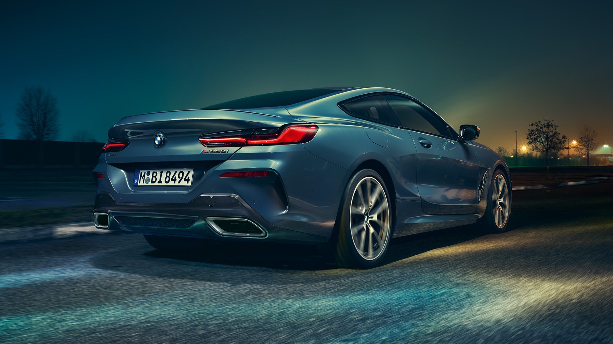 BMW M850i xDrive Coupé, vista posteriore G15. BMW M850i xDrive Coupé in Barcelona Blue metallizzato, vista posteriore, in marcia di notte G15.
