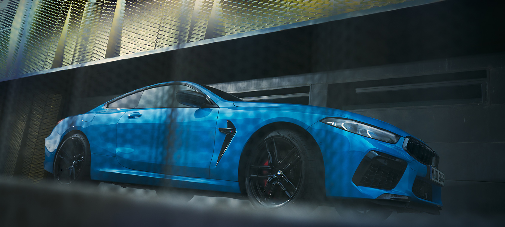 BMW M8 Competition Coupé F92 LCI Facelift 2022 Vista laterale da ferma con prospettiva dal basso BMW M8 Competition Coupé F92 LCI Facelift 2022 BMW Individual Daytona Beach Blue pastello vista laterale da ferma davanti a edificio con prospettiva dal basso