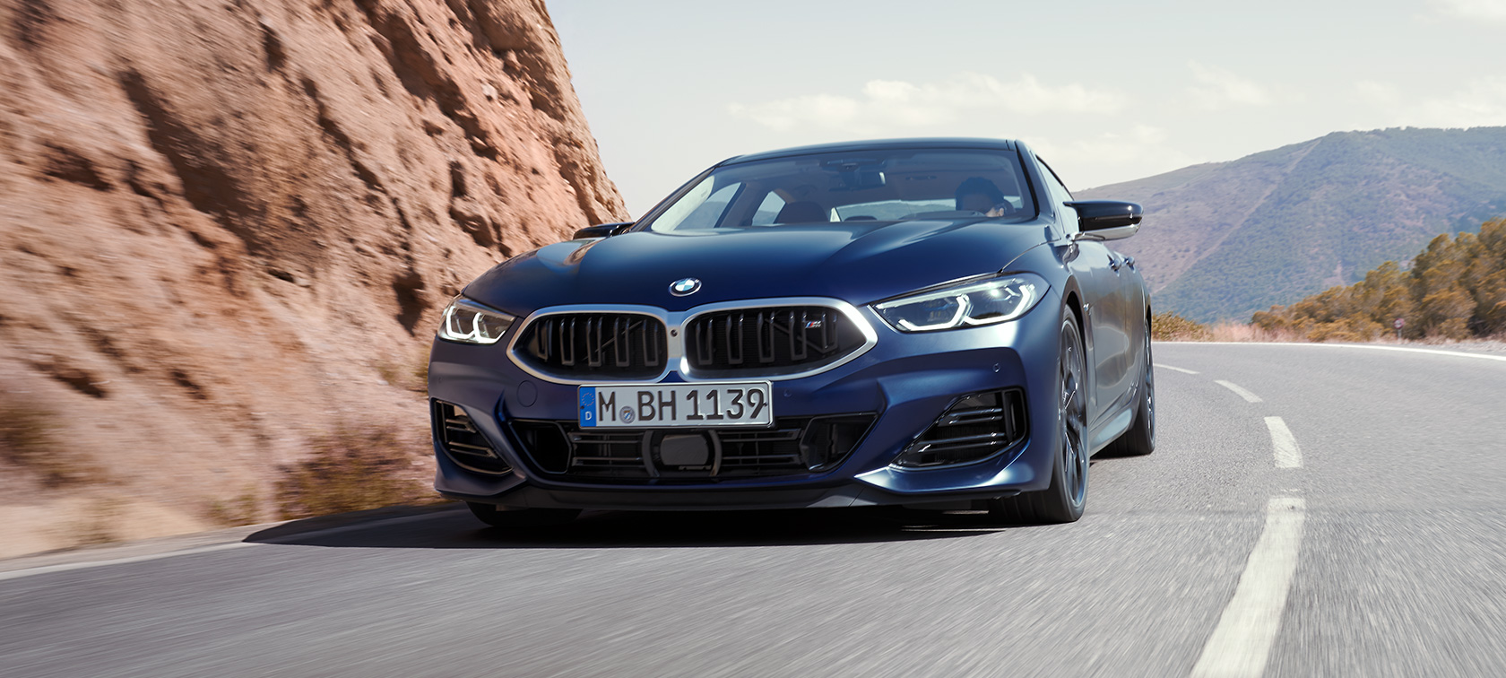 Vista anteriore a tre quarti in movimento della BMW M850i xDrive Gran Coupé G16 LCI Facelift 2022 BMW M850i xDrive Gran Coupé G16 LCI Facelift 2022 BMW Individual Frozen Tansanite Blue metallizzato Vista anteriore a tre quarti in movimento in curva
