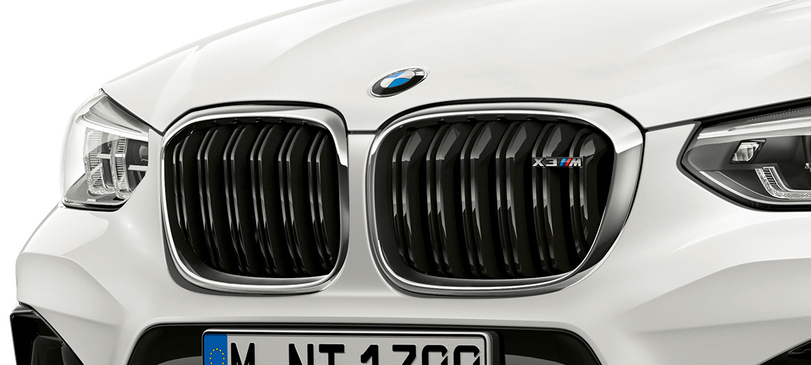 BMW X3 M, doppio rene M. F97 BMW X3 M in Alpine White, esterni, vista anteriore, doppio rene M con particolari cromati e denominazione del modello. F97