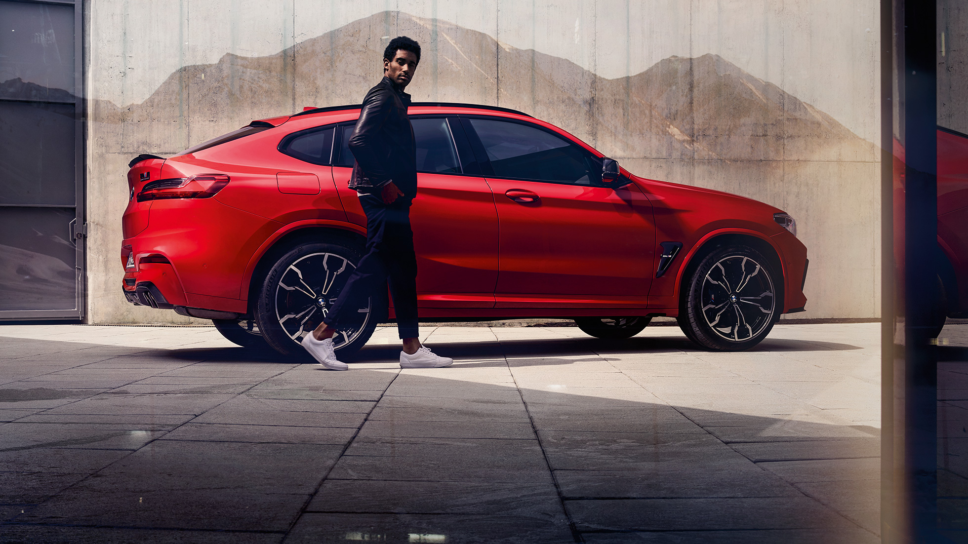 BMW X4 M Competition, vista laterale con ragazzo F98. BMW X4 M Competition in Toronto Red metallizzato, esterni, vista laterale con ragazzo F98.