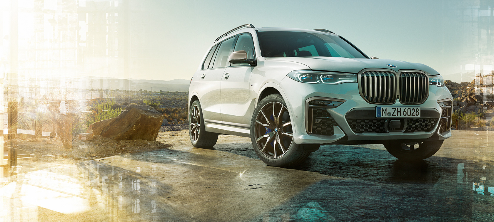 Automobile BMW X7 M, vista anteriore a tre quarti sinistra Automobile BMW X7 M in Mineral White, G07, da ferma, vista anteriore a tre quarti sinistra