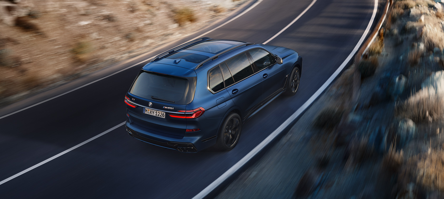 BMW X7 M60i xDrive G07 LCI Frozen Marina Bay Blue tre quarti posteriore vista a volo d'uccello dirving sulla strada BMW X7 M60i xDrive G07 LCI Frozen Marina Bay Blue tre quarti posteriore vista a volo d'uccello dirving sulla strada