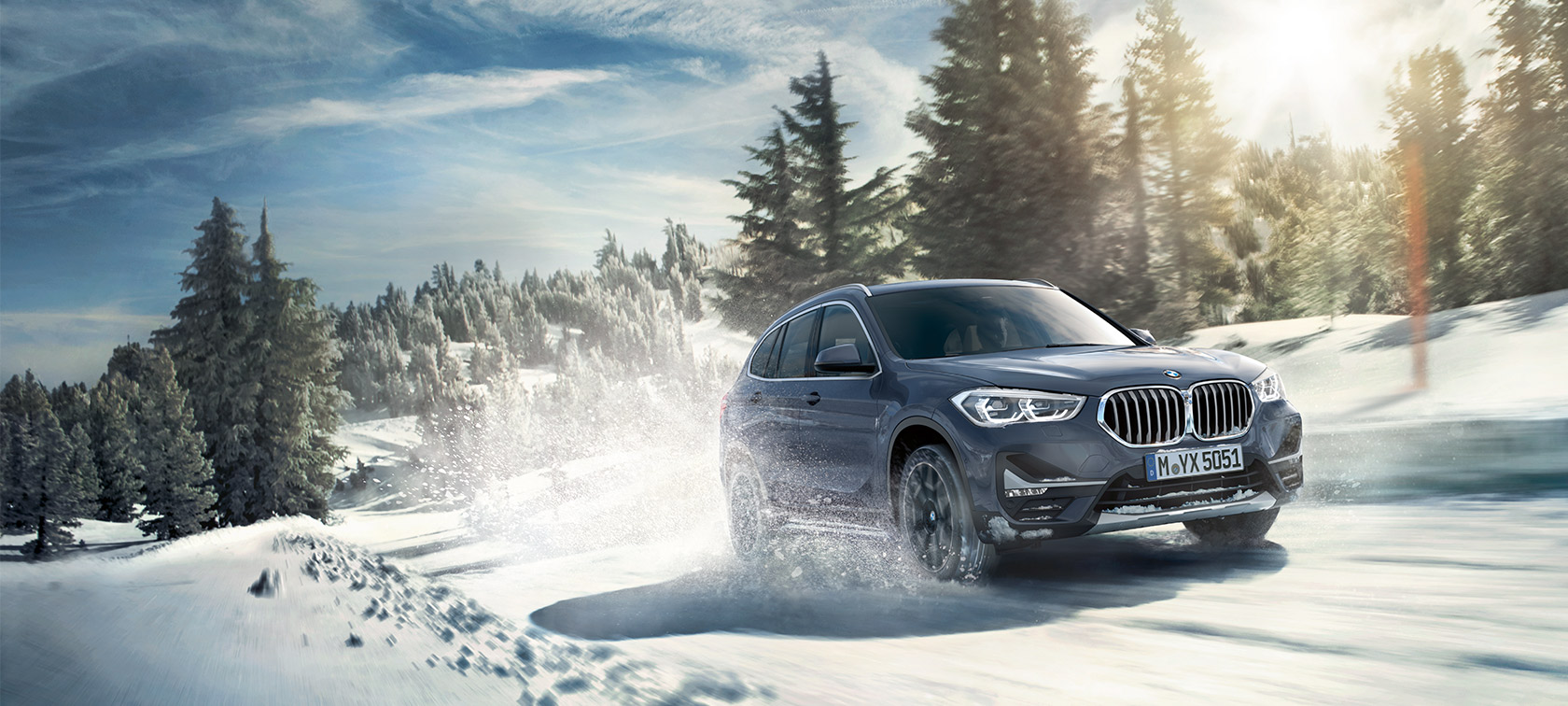 BMW X1 xDrive20i F48 LCI in BMW Individual Storm Bay metallizzato, in movimento con paesaggio invernale BMW X1 xDrive20i F48 LCI in BMW Individual Storm Bay metallizzato, in movimento con paesaggio invernale