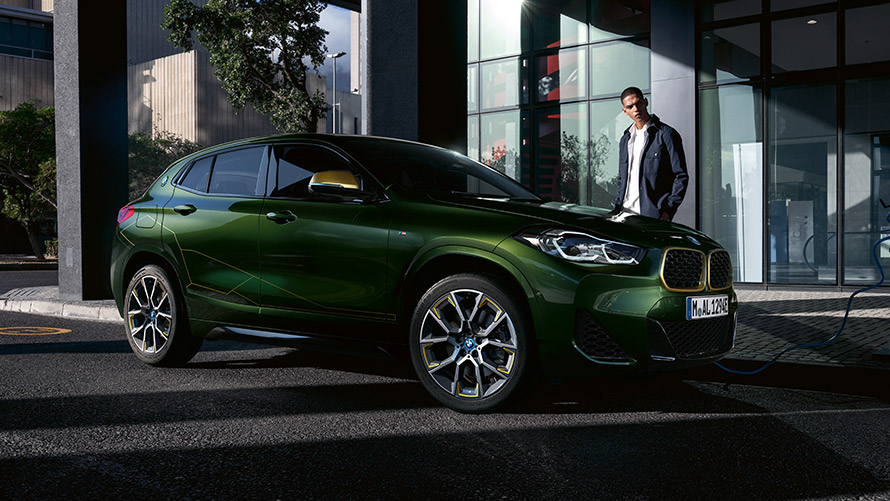 BMW X2 F39 in Sanremo Green metallizzato vista laterale a tre quarti con modella BMW X2 F39 in Sanremo Green metallizzato vista laterale a tre quarti con modella