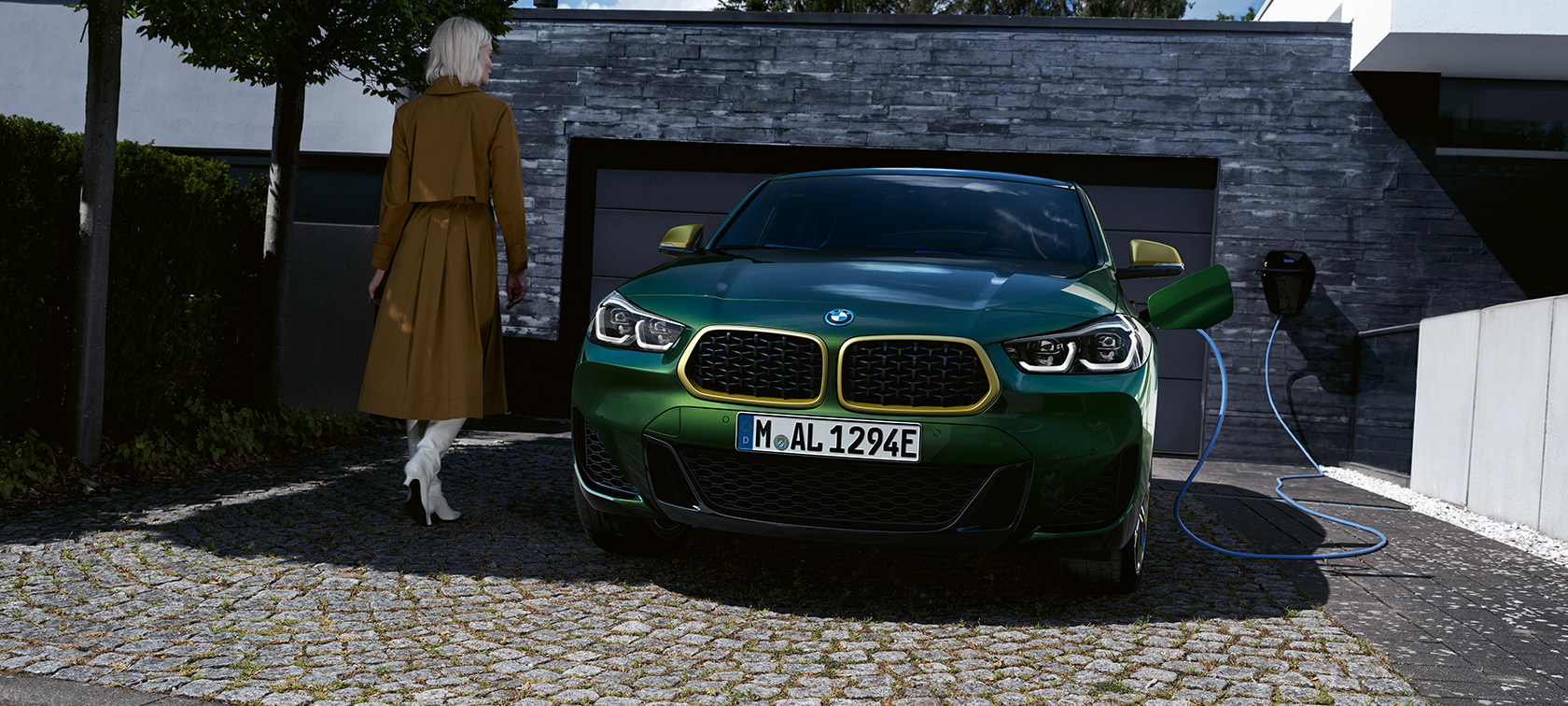 Vista anteriore della BMW X2 F39 in Sanremo Green metallizzato Vista anteriore della BMW X2 F39 in Sanremo Green metallizzato in ricarica con modella