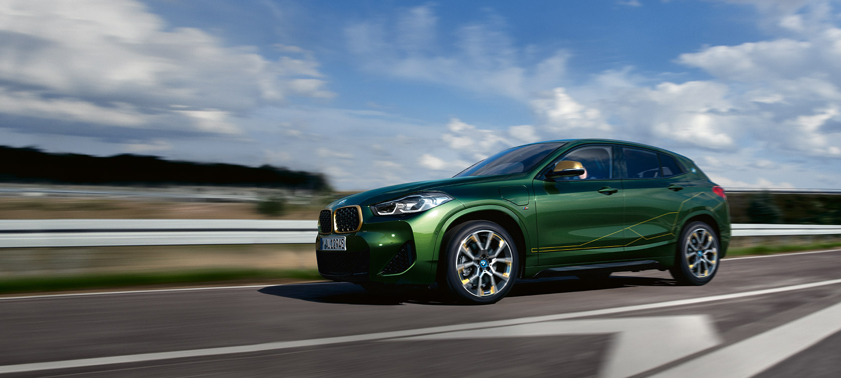 Vista laterale a tre quarti in movimento della BMW X2 F39 Sanremo Green metallizzato