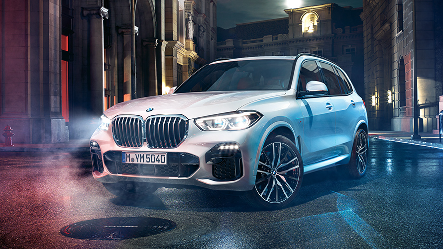 Immagine anteriore della BMW X5 di notte in ambiente urbano