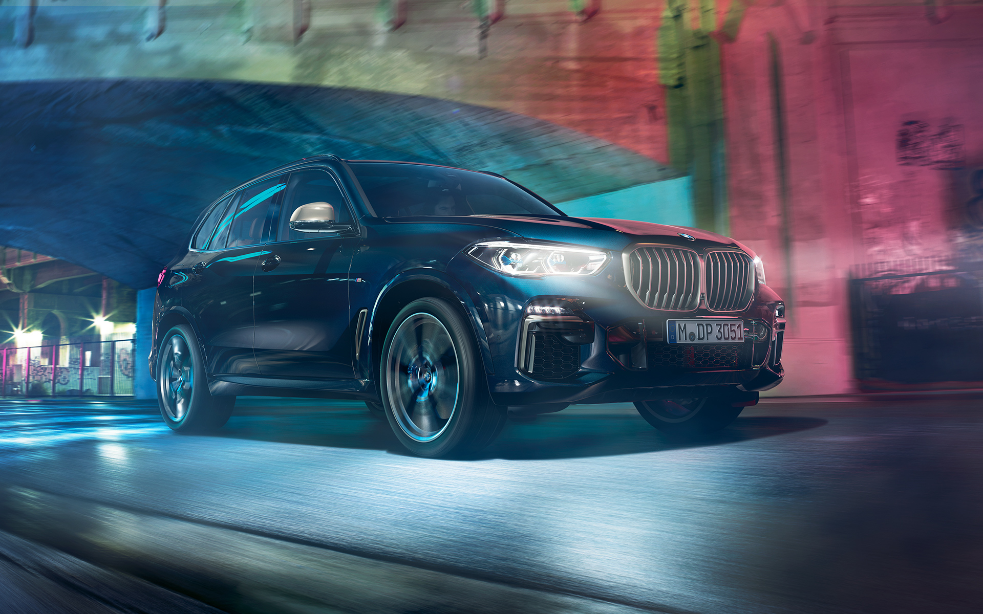 BMW X5 M50d in azione Immagine della BMW X5 M50d guidata di notte in città