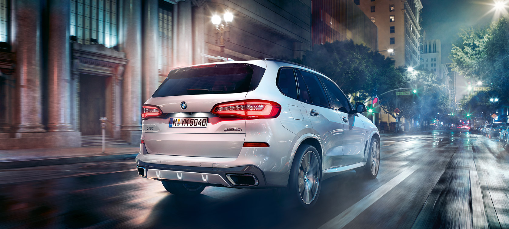 BMW X5 vista posteriore a tre quarti in movimento G05 BMW X5 G05 2018 Mineral White metallizzato vista posteriore a tre quarti in movimento