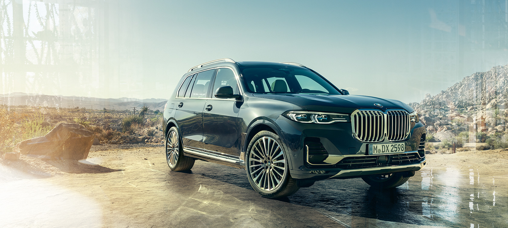BMW X7, vista anteriore a tre quarti da sinistra G07 BMW X7 in Artic Grey, vista anteriore a tre quarti da ferma con il deserto sullo sfondo, G07 2019