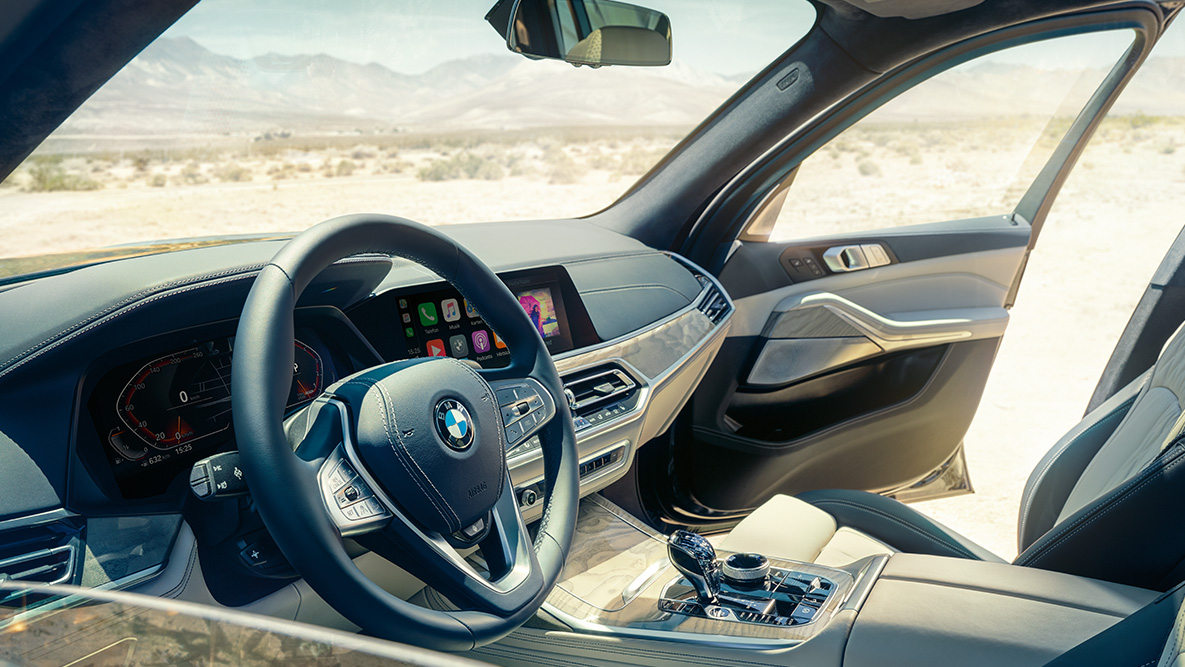 Interni della BMW X7 Interni della BMW X7: vista dall’esterno della prima fila di sedili con vista di volante, plancia strumenti e sedili in pelle