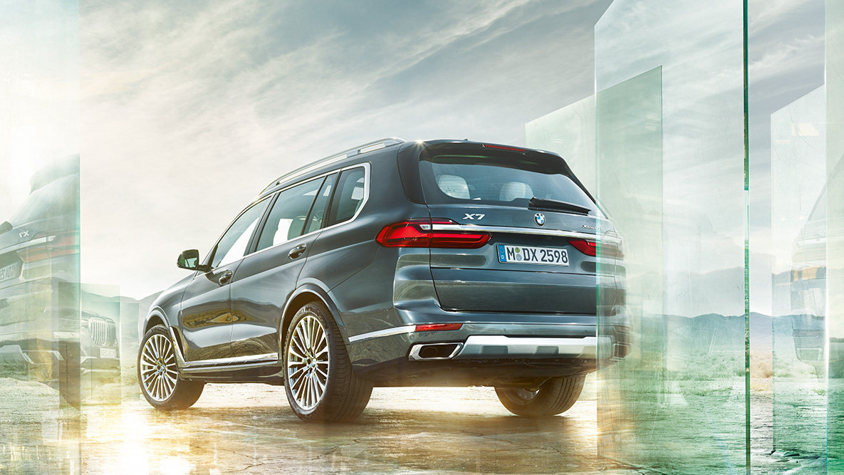 Dinamica di guida e comfort della BMW X7 Vista posteriore a tre quarti della BMX X7 su sfondo astratto
