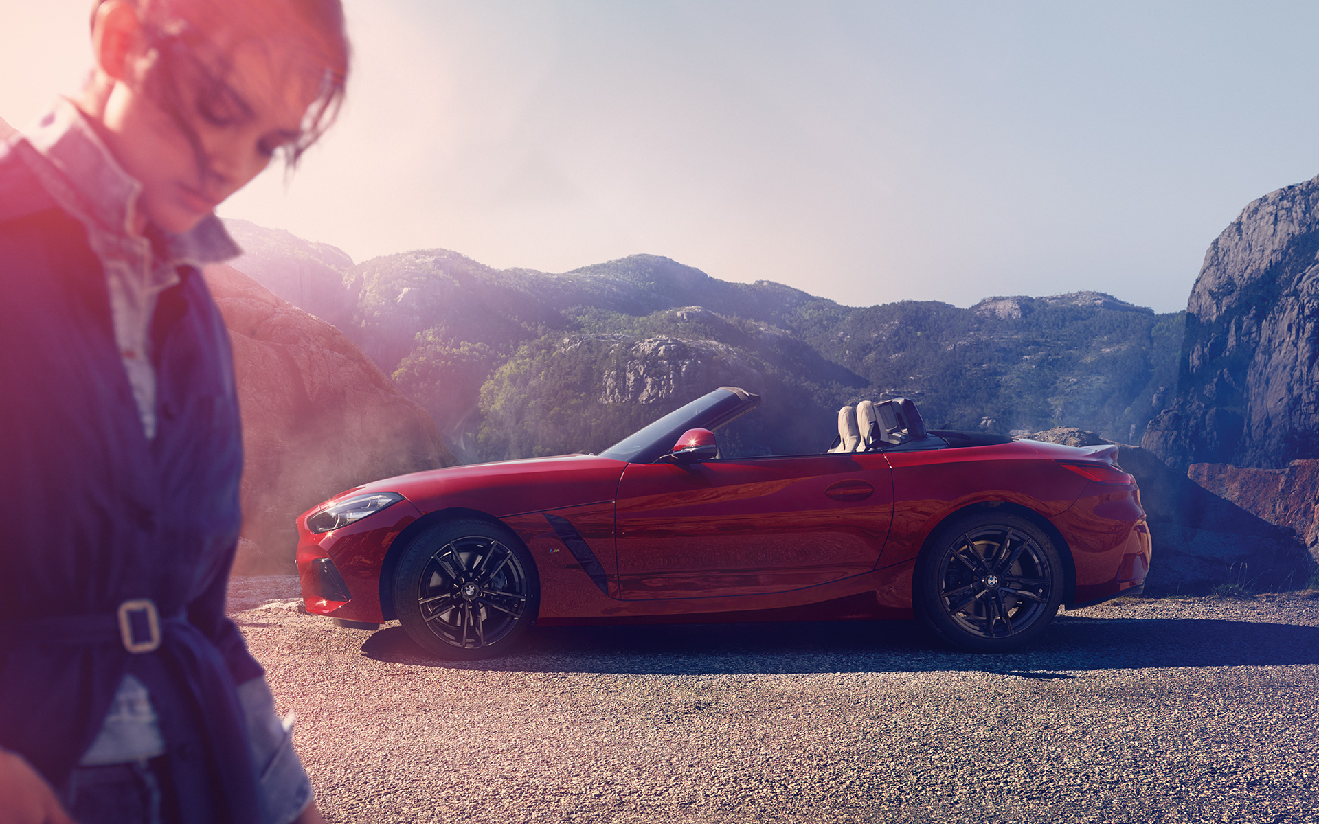 BMW Z4 Roadster (G29) in un paesaggio collinare Modella davanti alla BMW Z4 Roadster (G29) in un paesaggio collinare