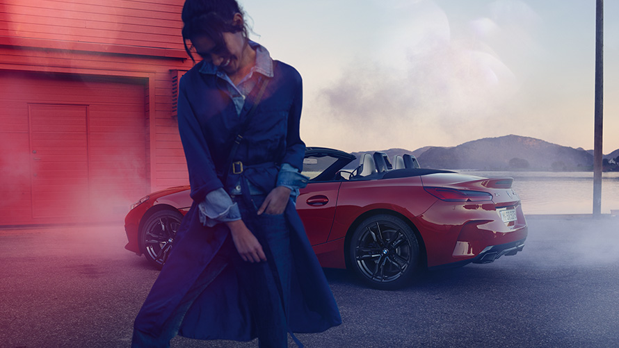 BMW Z4 M40i Roadster G29 con capote aperta BMW Z4 M40i Roadster G29 Vista posteriore a tre quarti con capote aperta e donna in primo piano