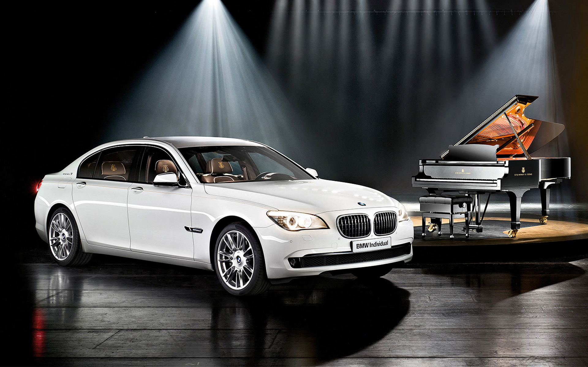 BMW Individual 7 Series Composition inspired by Steinway & Sons F01 2010 davanti a un pianoforte a coda BMW Individual 7 Saeries Composition inspired by Steinway & Sons F01 2010 Vista laterale a tre quarti davanti a un pianoforte a coda