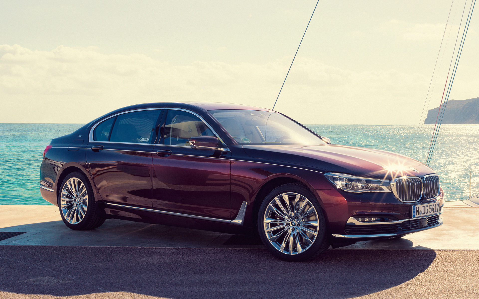 BMW Individual M760Li inspired by Nautor’s Swan G1 2017 davanti ad uno yacht BMW Individual M760Li inspired by Nautor’s Swan G12 2017 Vista laterale a tre quarti ferma am Pier davanti ad uno yacht in una baia