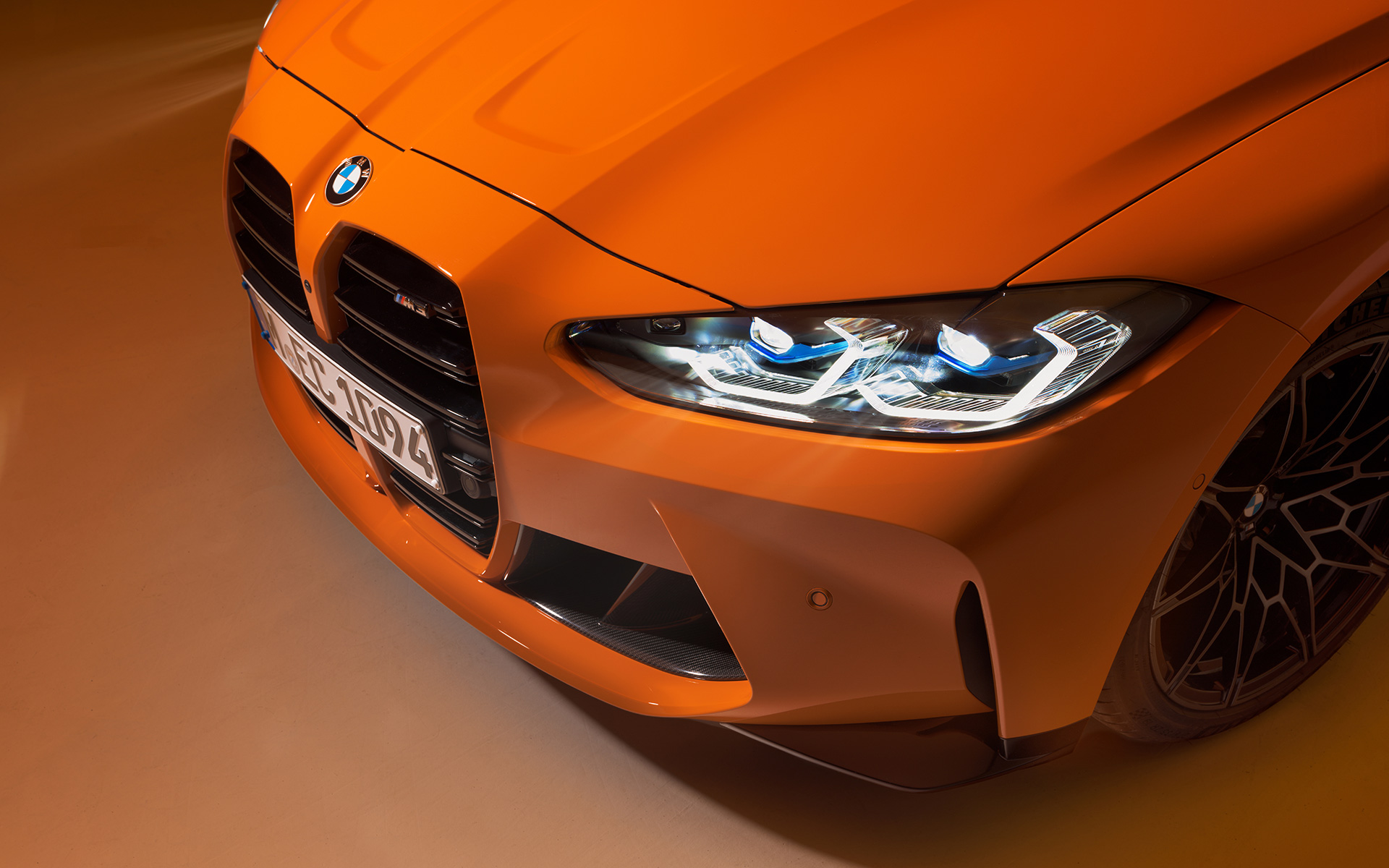 BMW M4 Competition Coupé G82 2021 BMW Fire Orange Individual Vista anteriore a tre quarti BMW M4 Competition Coupé G82 2021 Fire Orange BMW Individual Vista anteriore a tre quarti ferma, primo piano dall’alto