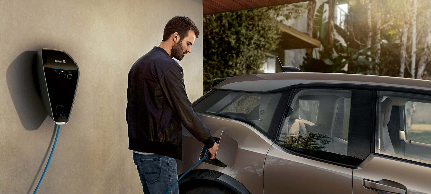 Un uomo ricarica la BMW i3. Un uomo ricarica la BMW i3 al BMW i Wallbox.