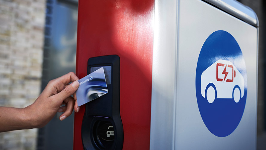 Ricarica pubblica con BMW Charging Card Una persona presso una stazione di ricarica pubblica tiene in mano la BMW Charging Card