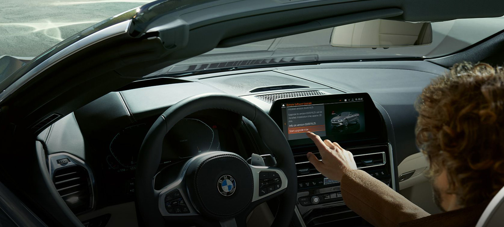 BMW Remote Software Upgrade Un uomo seduto nella BMW fa partire BMW Remote Software Upgrade