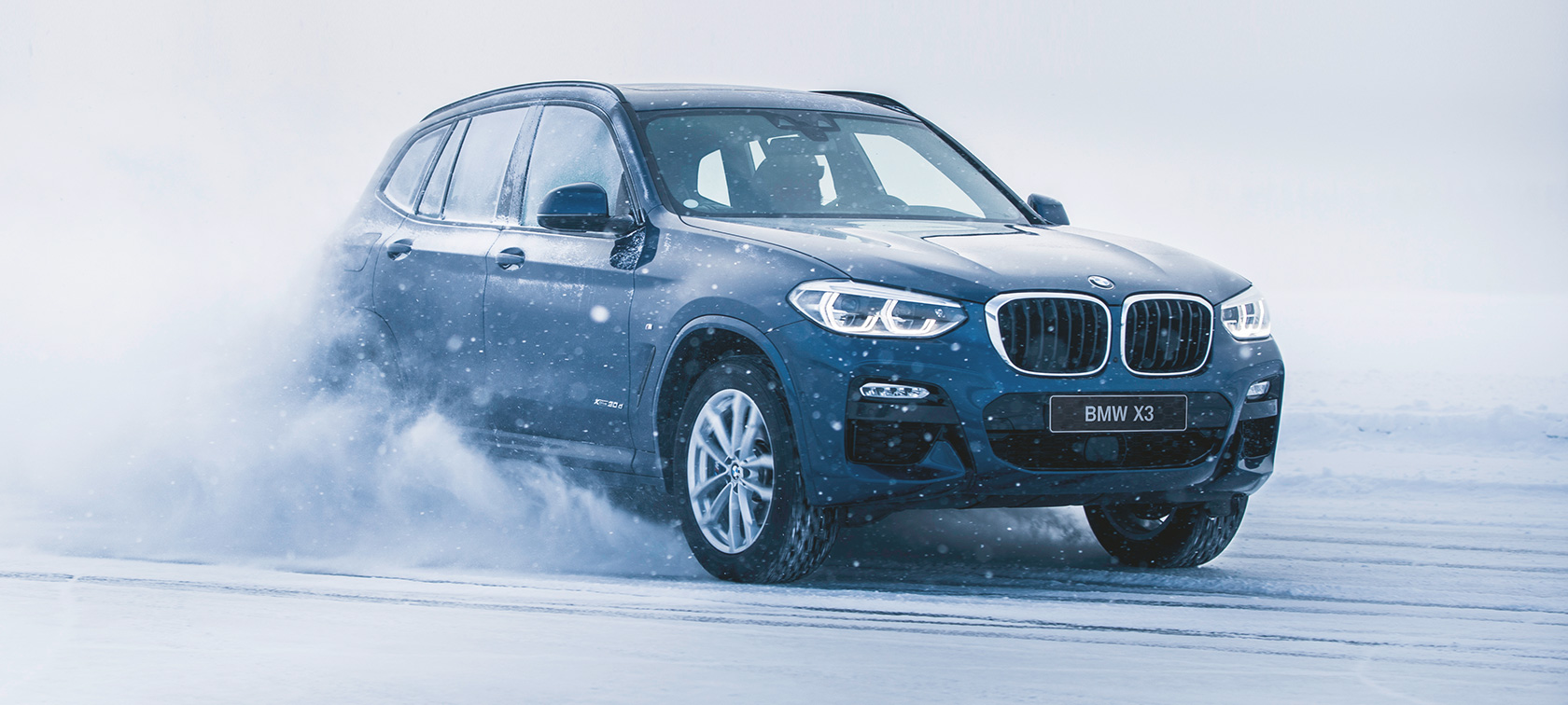 Accessori autunno-inverno BMW BMW X3 nella neve, vista anteriore a tre quarti