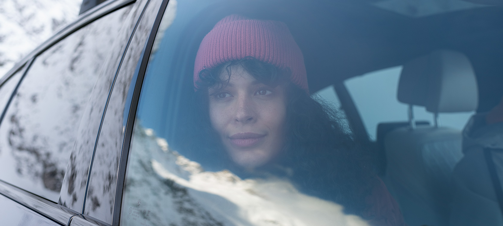 Una donna guarda fuori dal finestrino di una BMW Accessori autunno-inverno BMW Una donna guarda fuori dal finestrino di una BMW
