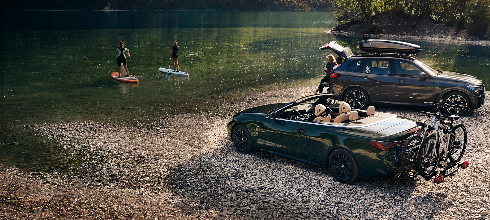 Accessori BMW primavera ed estateAuto BMW davanti a un paesaggio montano con lago