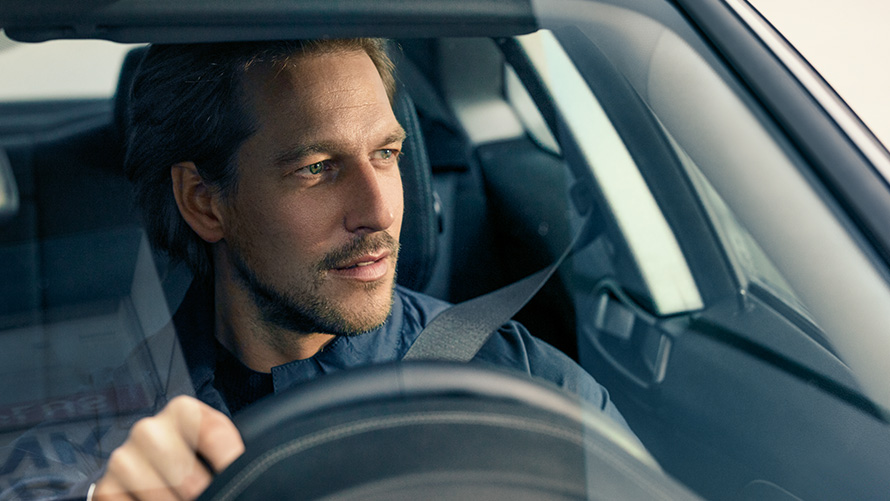 Uomo al volante di una BMW Uomo al volante di una BMW visto attraverso il parabrezza